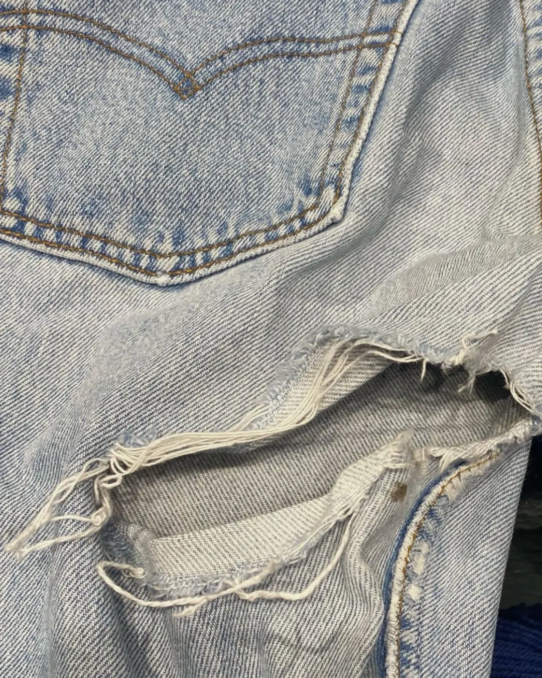 Postrzępione jeansy Levi's przed naprawą